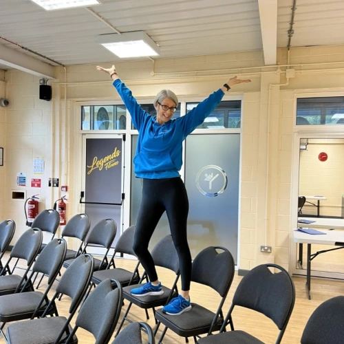 Natalie Bryden stood on chair with arms up